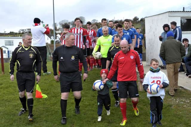 Match officials lead the  Greencastle FC and Derry City teams onto the pitch for the game in memory of Mark Farren, in Greencastle on Saturday afternoon last. DER0517GS103