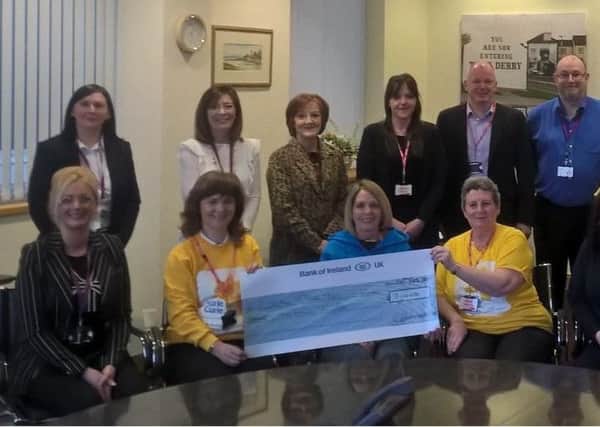 Staff from Computershare hand over the money they raised to the local charity representatives.