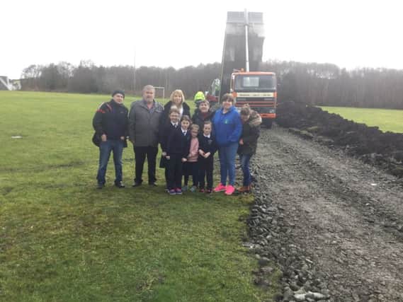 Sinn Fein's Tony McCaul and Cathal O'hOisin with community representatives and local school children close to where the new play park will be built.
