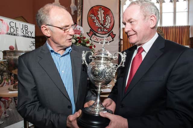 Tom McGuinness and his brother Deputy First Minister Martin McGuinness pictured in 2013 with the oldest piece of silverware in the history of the GAA in Derry, the 1891 County Championship Cup. Picture Martin McKeown. Inpresspics.com. 15.5.13
