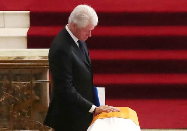 Former US President Bill Clinton touches the coffin of Martin McGuinness during yesterday's funeral Mass at St Columba's Church, Long Tower.