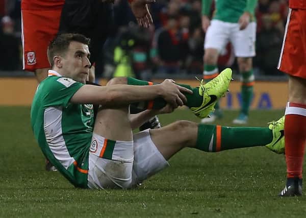 Republic of Ireland's Seamus Coleman holds his leg after a challenge from Wales' Neil Taylor