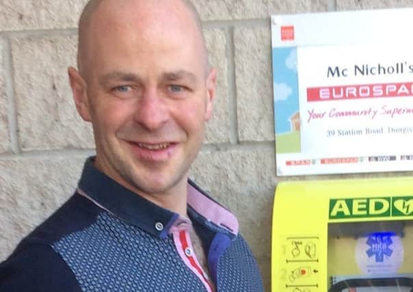 Kevin McCloy beside the new defibrillator at Eurospar in Dungiven