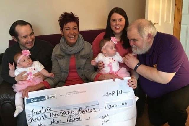 Garvin and Emma Harkin with the twins presenting a cheque to Tinylife representatives Lynn Patterson and Brian McCluskey.