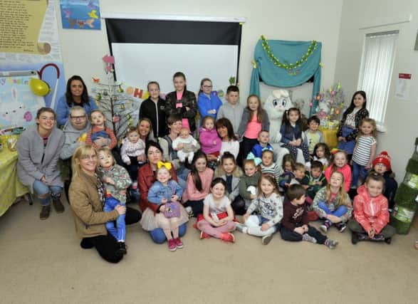 Margaret Cunningham, Habinteg Housing Farland Way Community Support Worker (centre), pictured with children and parents who attended the recent COSY Club Easter event.  DER1617GS006