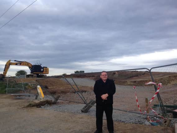 Sinn Fein Councillor Tony Hassan next to the building site.