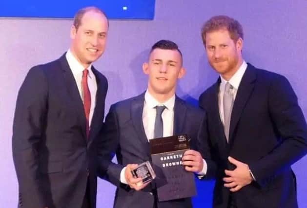 Derry teenager Garreth Browne pictured getting his award from Princes William and Harry.
