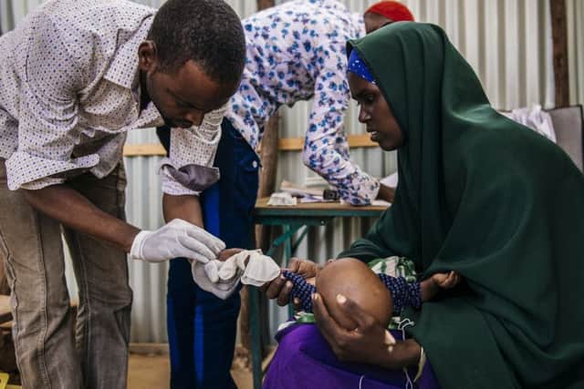 Antal Abdi Haji has her severely dehydrated son, Rahma, examined by personnel at Akara CTC. Photo: Amunga Eshuchi.