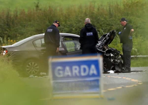 Garda look at one of the cars involved at the scene near Aclint Bridge in Ardee, Co Louth, after three women were killed and two men seriously injured in a road accident involving three cars.