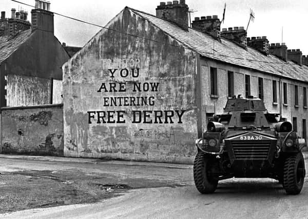 1971... A British Army armoured vehicle passes Free Derry Corner in Derrys Bogside.