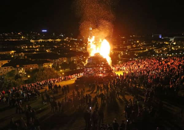 People watch a bonfire in the Bogside area, which is traditionally torched on August 15 to mark a Catholic feast day celebrating the assumption of the Virgin Mary into heaven, but in modern times the fire has become a source of contention and associated with anti-social behaviour. PRESS ASSOCIATION Niall Carson.