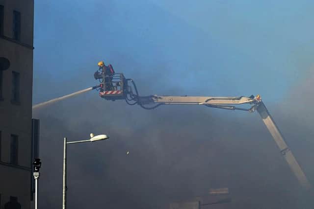 A firefighter moves in on the aerial appliance during the blaze at the Mandarin Palace restaurant along Queens Quay. DER1015MC106