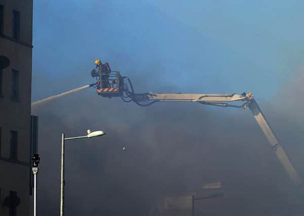 A firefighter moves in on the aerial appliance during the blaze at the Mandarin Palace restaurant along Queens Quay. DER1015MC106