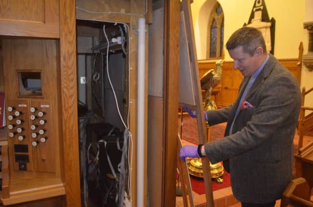 Archdeacon Robert Miller surveys the damage caused during this week's break-in at Christ Church.