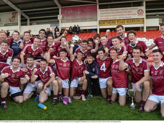 The Slaughtneil players celebrate with the John McLaughlin Cup after defeating Ballinascreen at Celtic Park.