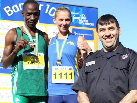 Gideon Kipsang and Laura Graham won the top prizes at the Bangor 10K, in association with George Best Belfast City Airport, as a record number of runners took part in the popular event. Congratulating the winners is Rory Goldring, Airport Fire Service Crew Commander at Belfast City Airport