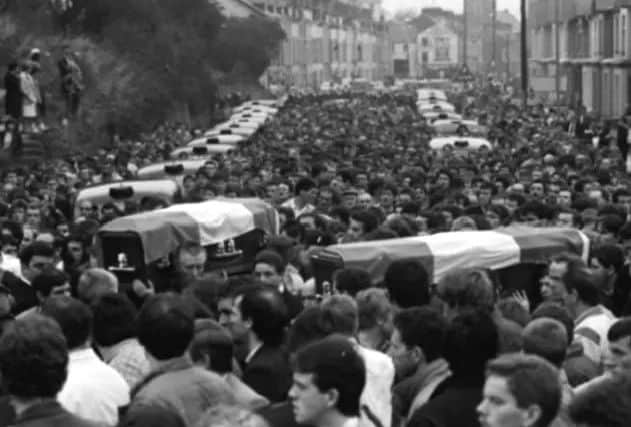 The funeral procession holding aloft the coffins of Eddie McSheffrey and Paddy Deery.