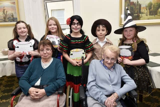 Brooklands Edenballymore Lodge residents Mary-Ann Grundluss and Mavis Houston pictured with some of the P6 pupils from Rosemount Primary School who read their Halloween stories during a visit to the home as part of a Verbal Arts Centre Reading Rooms intergenerational event. DER4317-123KM