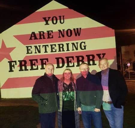 Foyle MLAs Raymond McCartney and Karen mullan with Councillors Eric McGinley and paul Fleming as Free Derry Wall is lit up in the colours of the Catalonian flag on Sunday night.