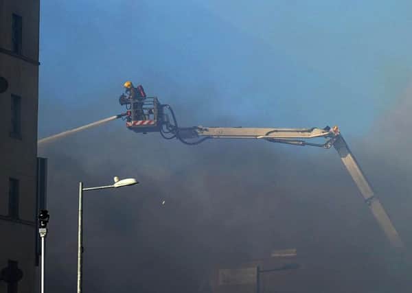 A firefighter moves in on the aerial appliance during the blaze at the Mandarin Palace restaurant along Queens Quay in 2015. DER1015MC106
