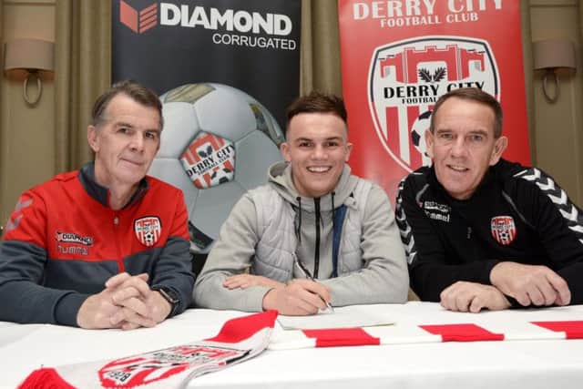 Rory Hale, grandson of Danny Hale, signing for Derry City at the Bishop's Gate Hotel yesterday. Included are team manager Kenny Shiels and assistant manager Hugh Harkin. DER4517-140KM